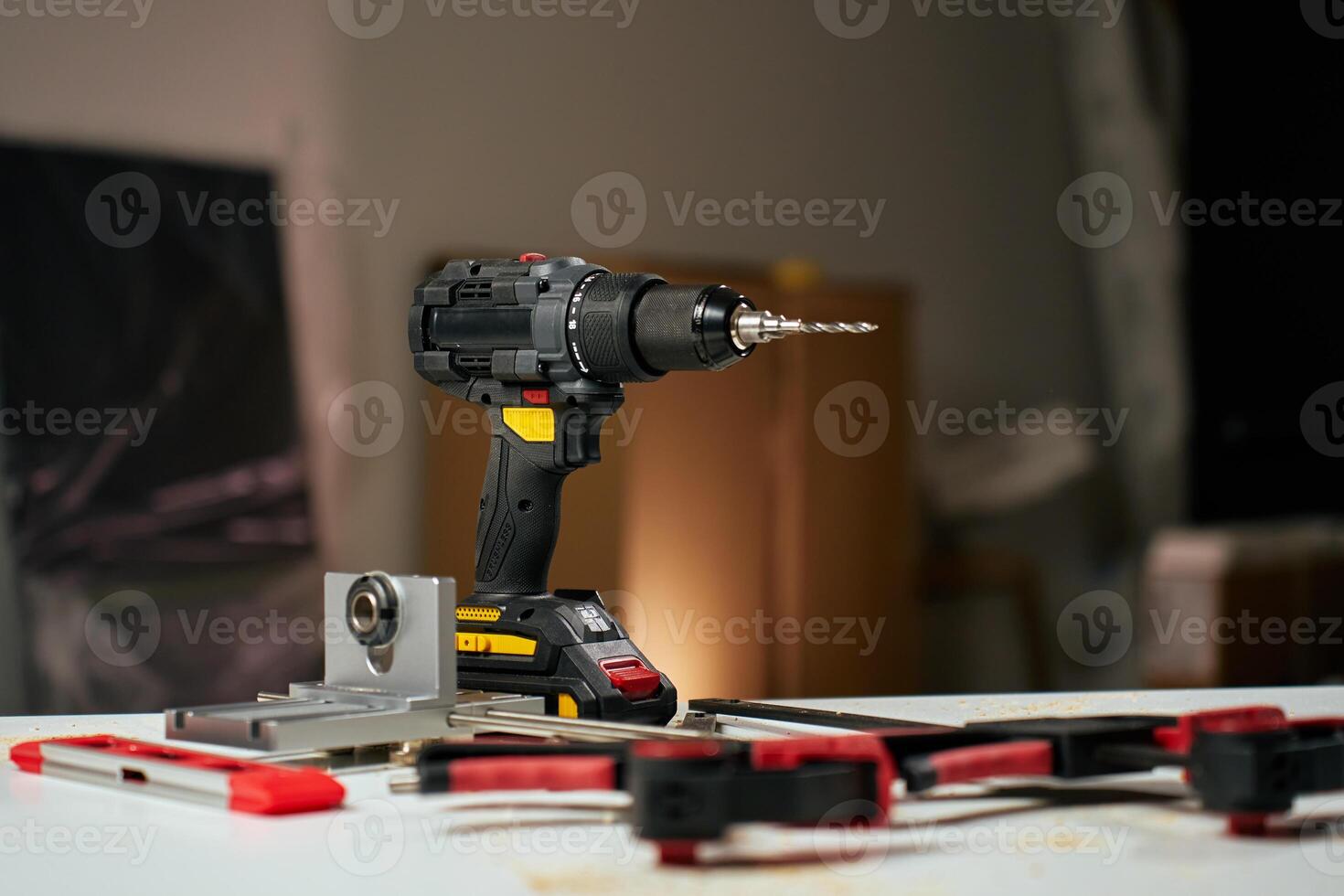 Electric cordless drill with bits and hand tools on workbench in workshop. Home renovation and repair concept photo