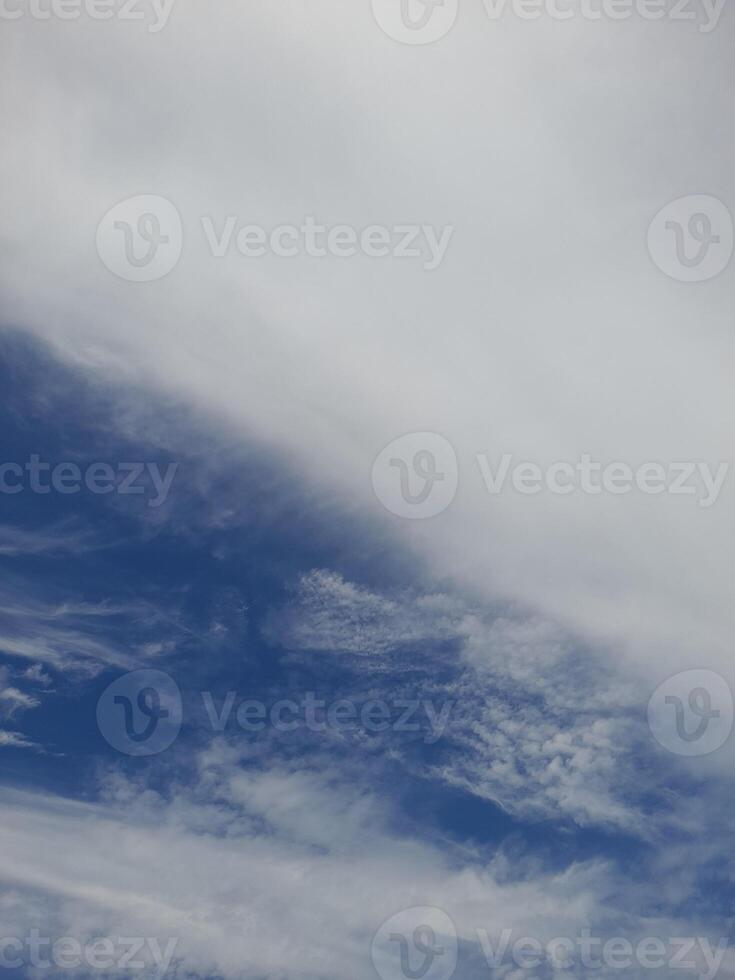 A bright blue sky with soft, scattered white clouds drifting peacefully, creating a calm and serene atmosphere photo