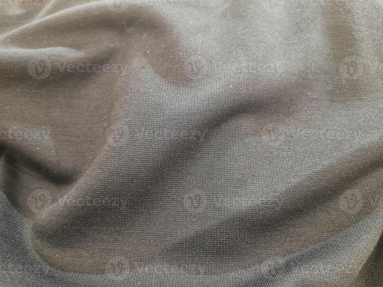 Smooth black fabric with a soft, clean texture and gentle folds, ideal for elegant and casual clothing. photo