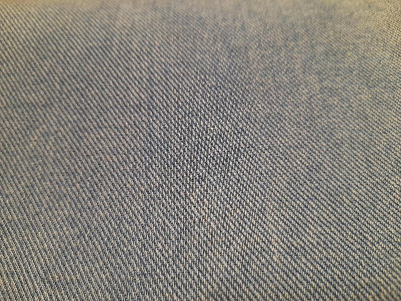 Close-up of a gray twill fabric with diagonal weave patterns, giving a textured yet smooth and durable appearance. photo