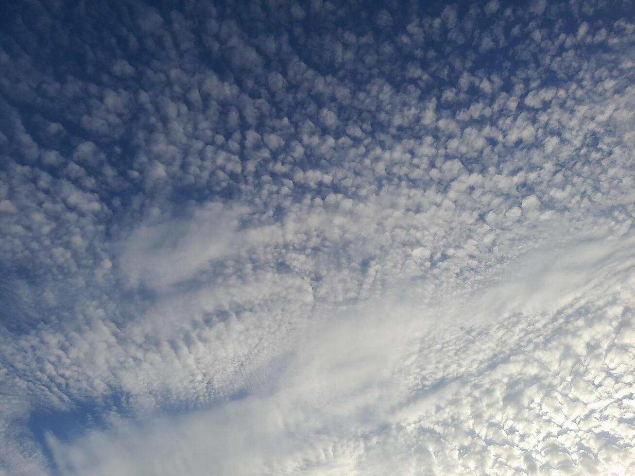 A beautiful sky filled with textured altocumulus clouds creating a soft and intricate pattern. photo