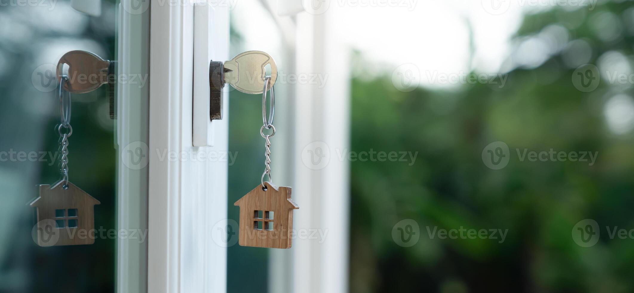 Landlord key for unlocking house is plugged into the door. Second hand house for rent and sale. keychain is blowing in the wind. mortgage for new home, buy, sell, investment photo