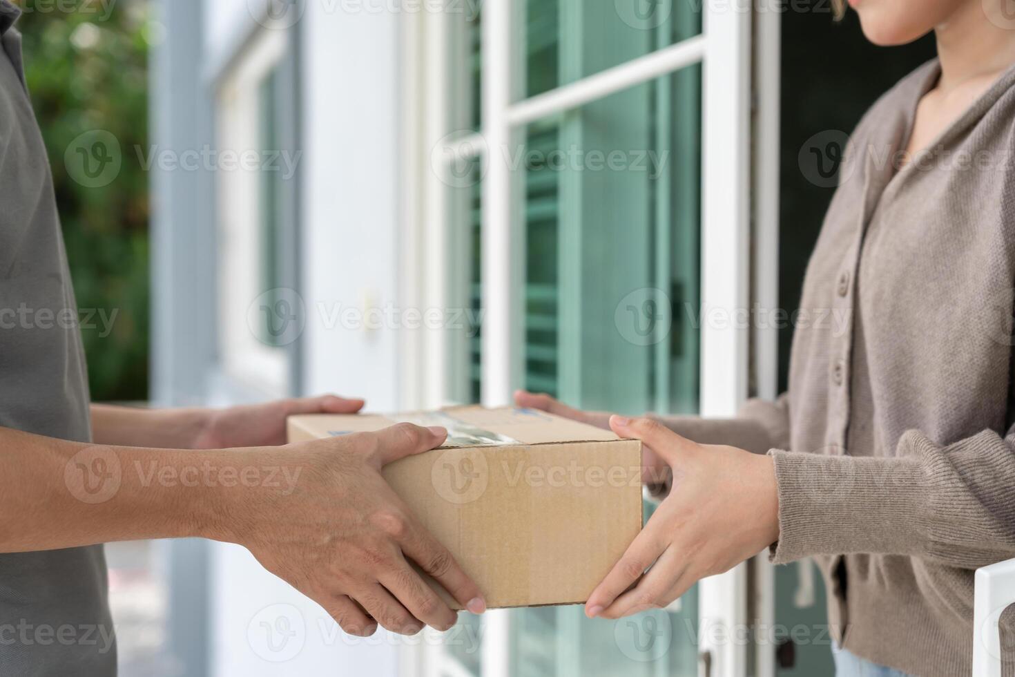 Happy smile woman receives boxes parcel from courier in front house. Delivery man send deliver express. online shopping, paper containers, takeaway, postman, delivery service, packages photo