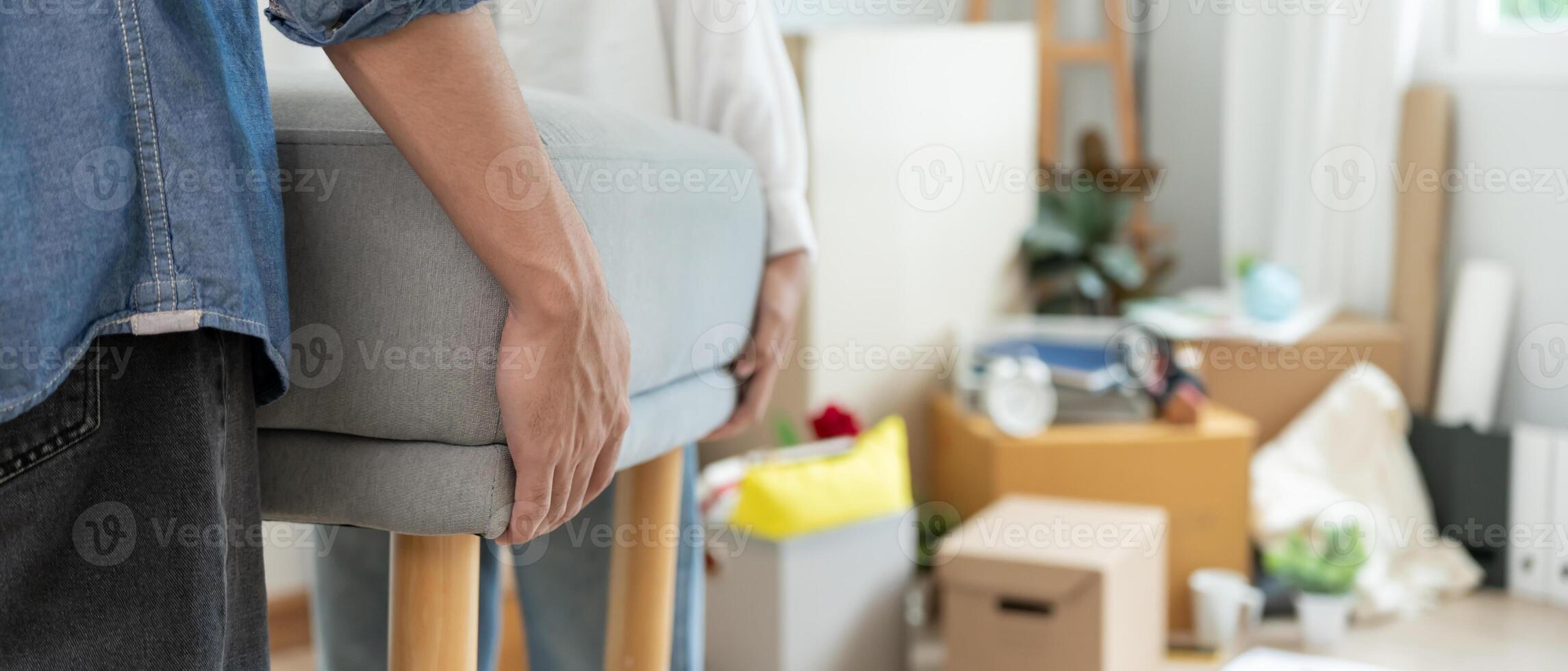Moving house, relocation. Couple help set sofa and move furniture for new apartment, inside the room was a cardboard box contain personal belongings. move in new apartment or condominium photo