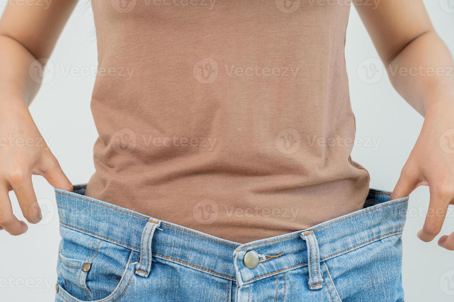 Woman show results of diet. Beautiful shape. female have a reduced waist size after under going a weight loss corse. can not wear jeans due to weight loss. balance, control, routines, exercise. photo
