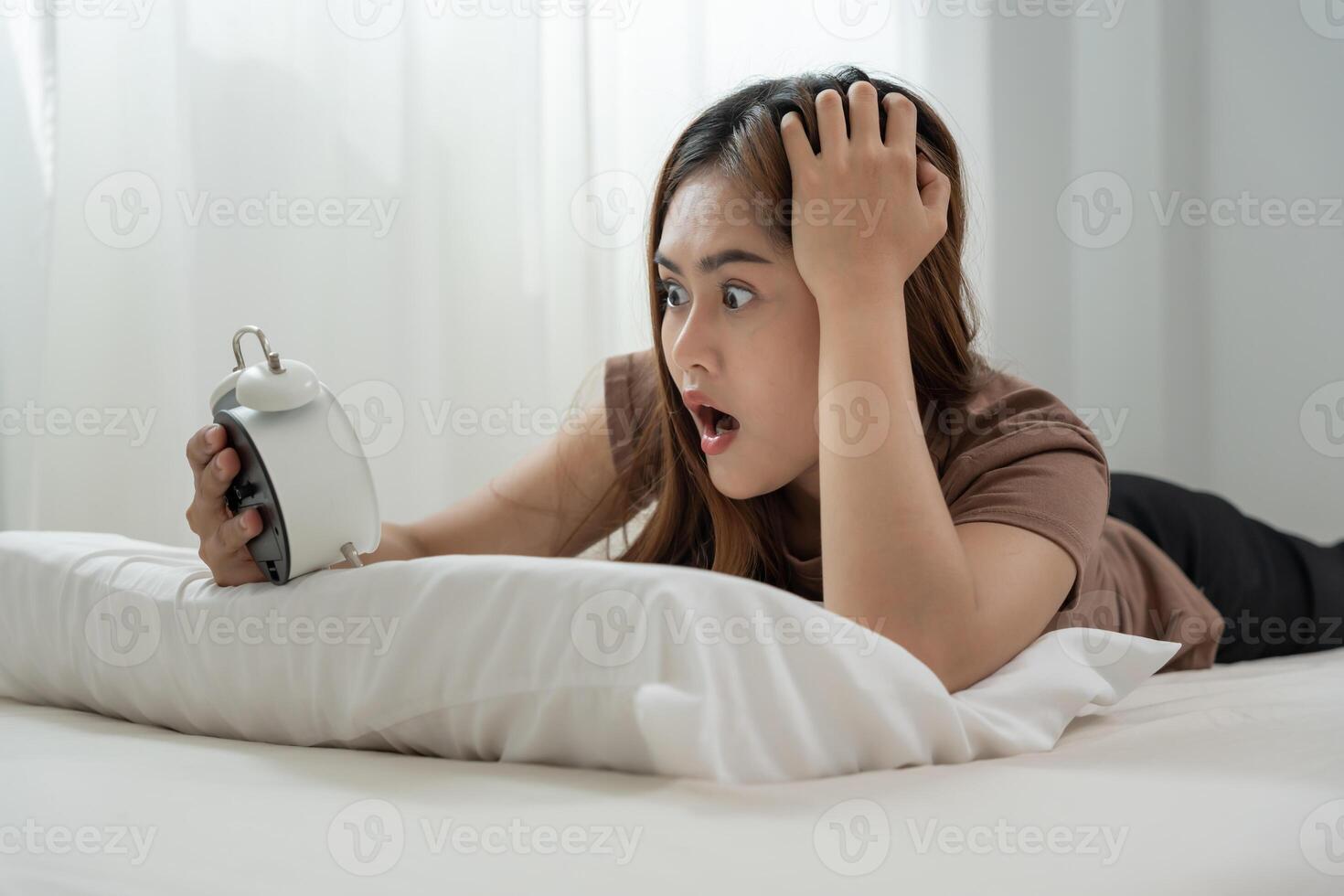 Shocked Asia young woman look clock alarm, lady is late appointment or work or class study, overslept, difficulty get up in mornings, time worried, not on time, sleepy, over due, Hurry up time photo