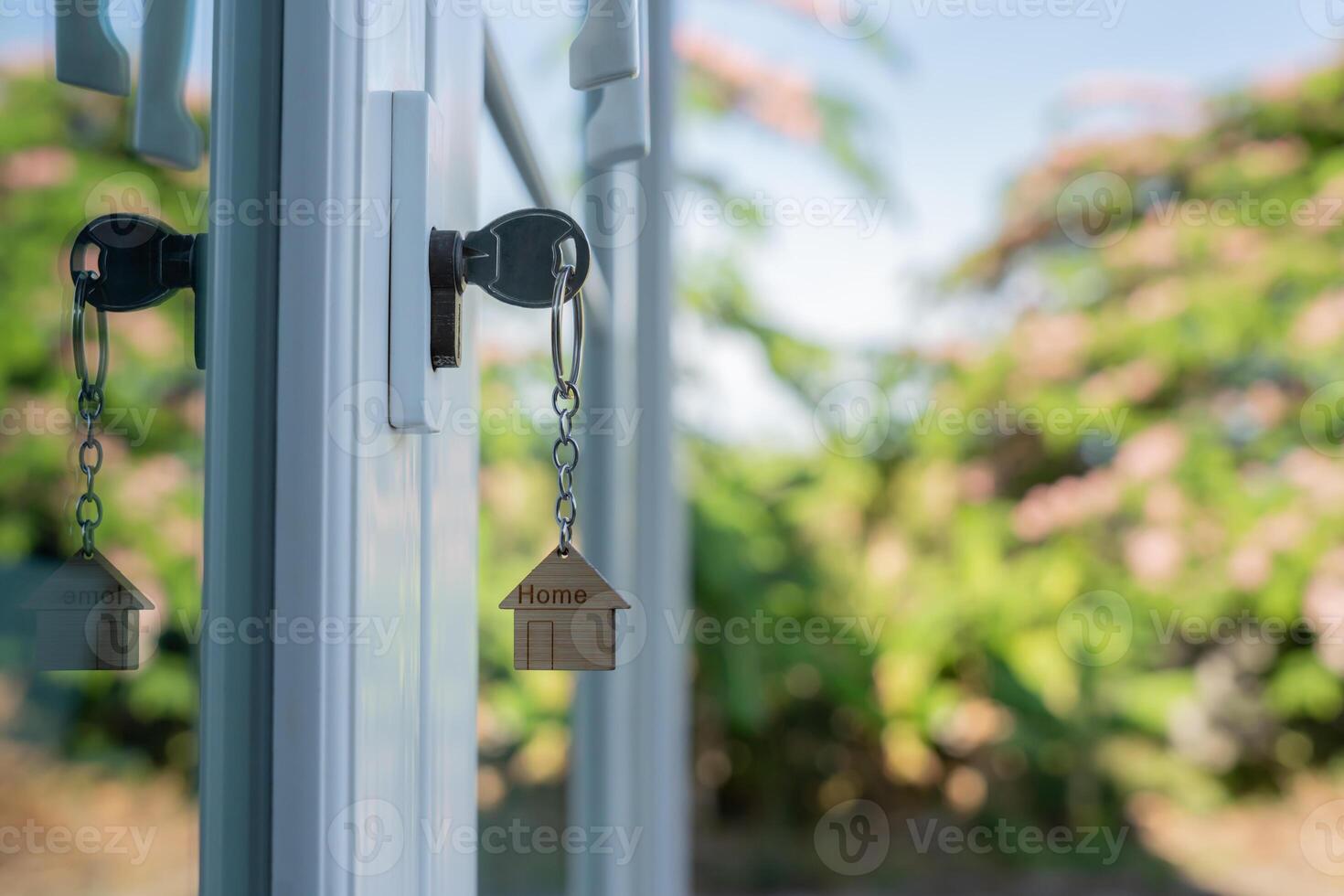 unlocking house is plugged in the door. Second hand house for rent and sale. keychain is blowing in the wind. mortgage for new home, buy, sell, renovate, investment, owner, estate photo