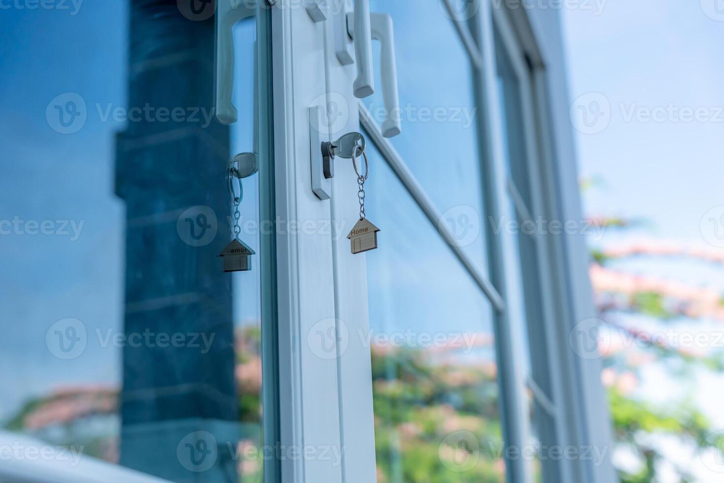 unlocking house is plugged into the door. Second hand house for rent and sale. keychain is blowing in the wind. mortgage for new home, sell, renovate, investment, owner, estate photo