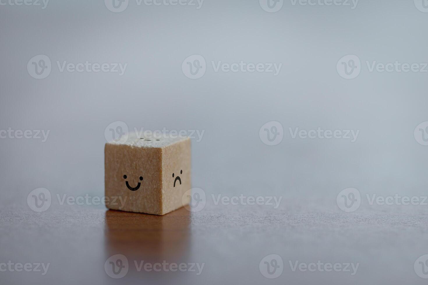 Wooden Cube with Happy and Sad Faces. Concept of Emotional Balance and Expression. photo