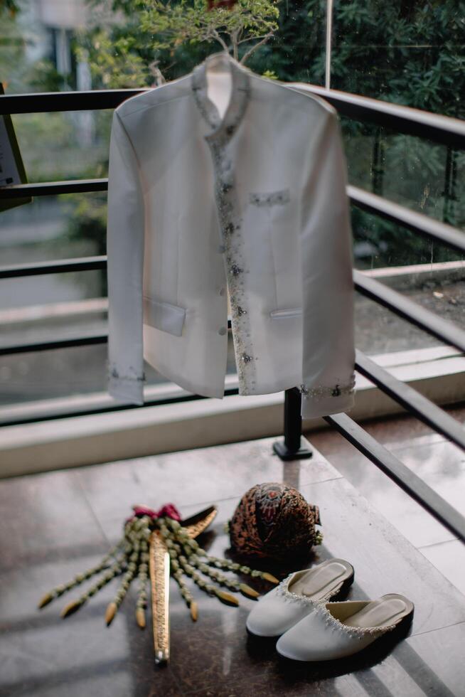 a white jacket, shoes and a flower are on a balcony photo