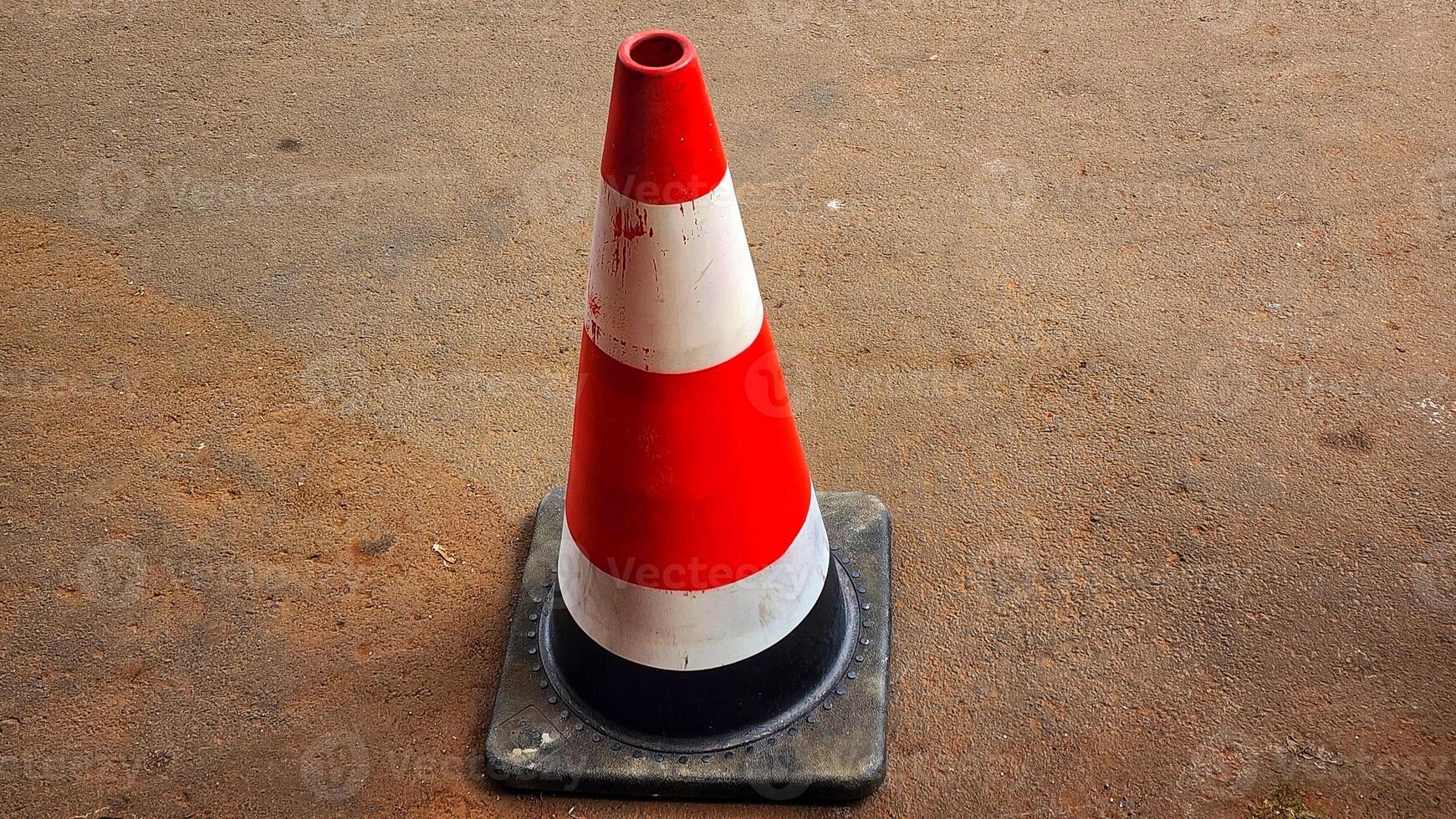 A traffic cone on a concrete surface photo