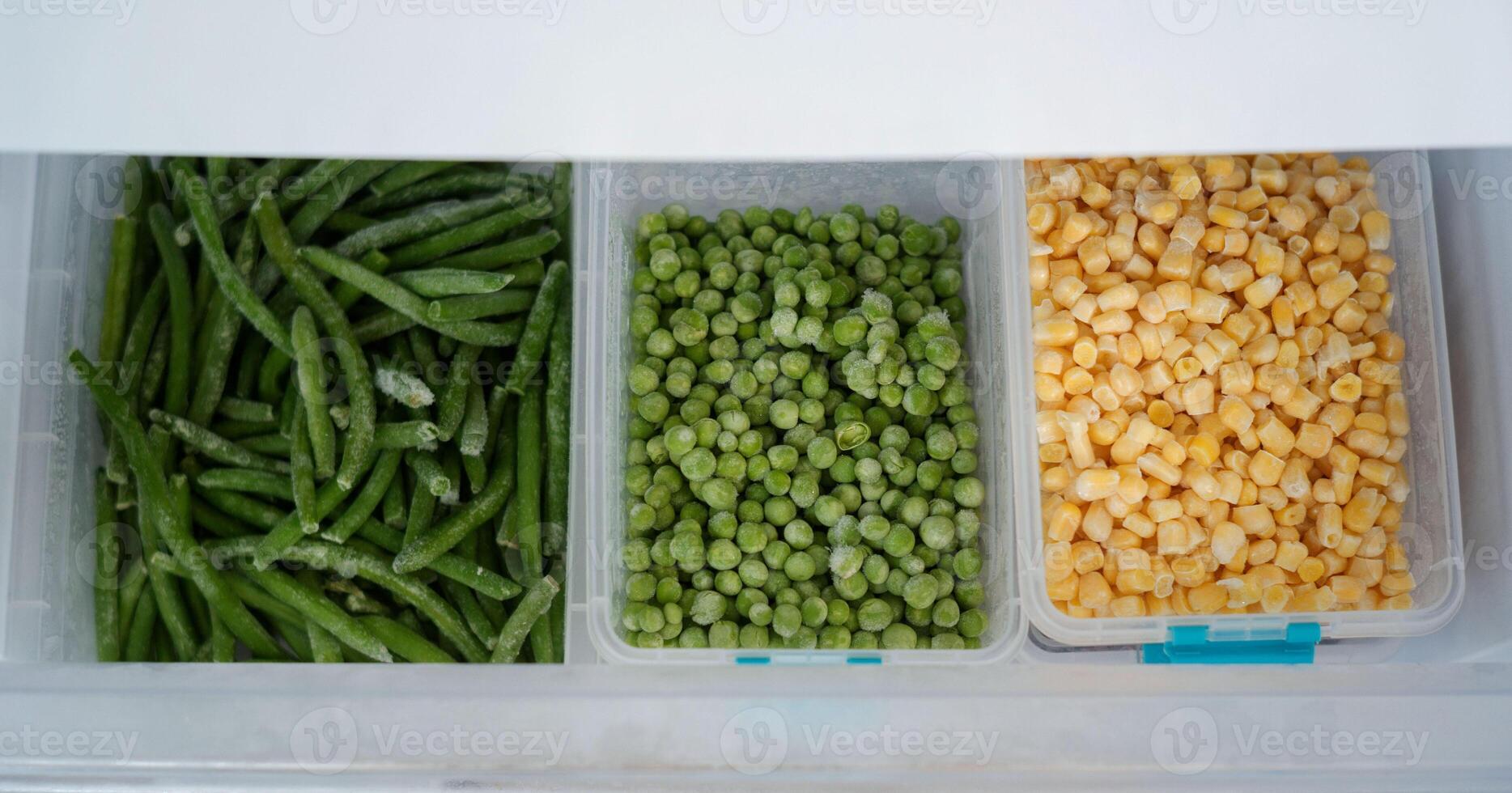 Frozen green beans, peas, and corn preserving freshness in refrigerator photo