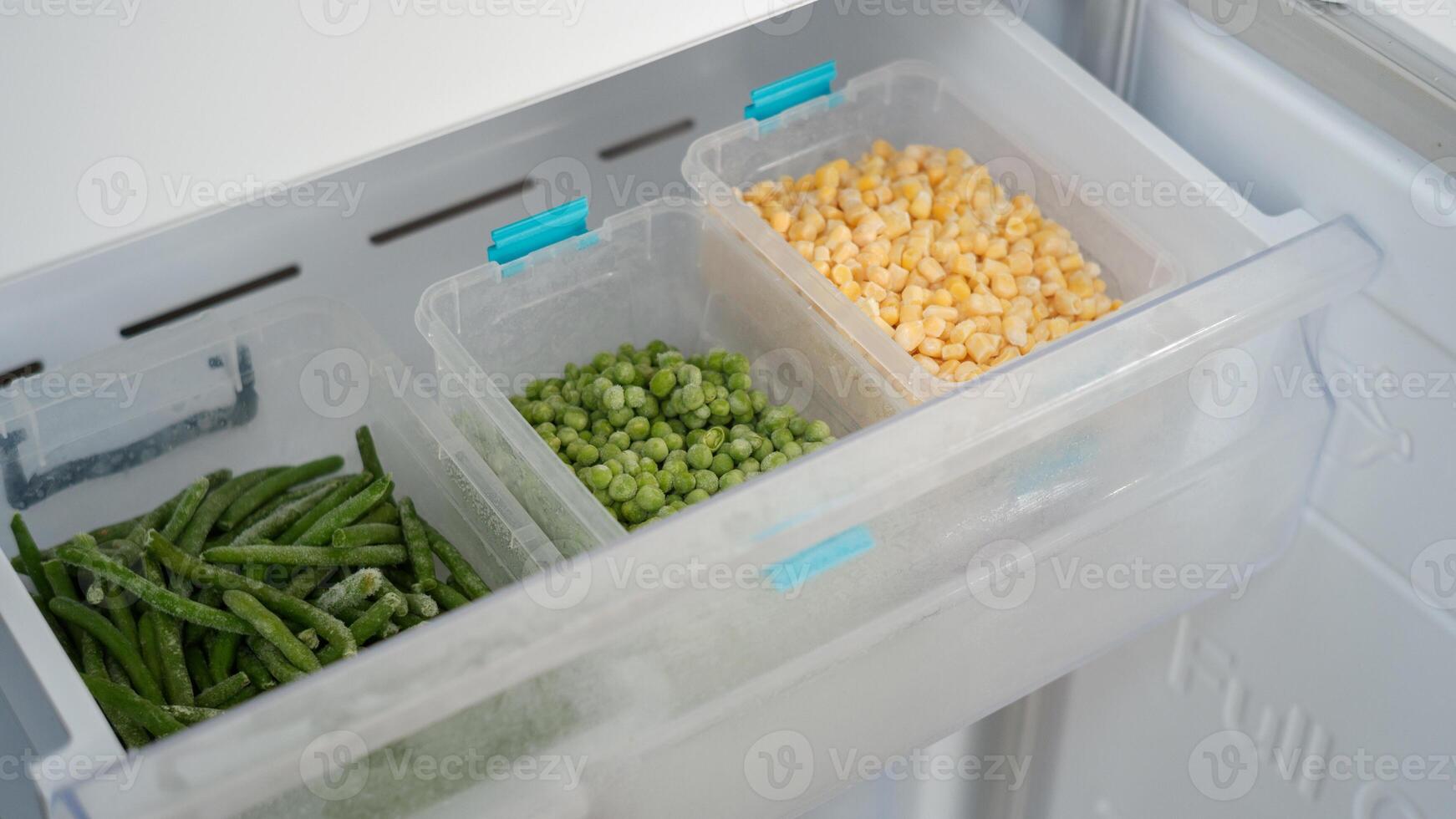Frozen vegetables preserving freshness in refrigerator drawer. peas, corn, and green beans photo