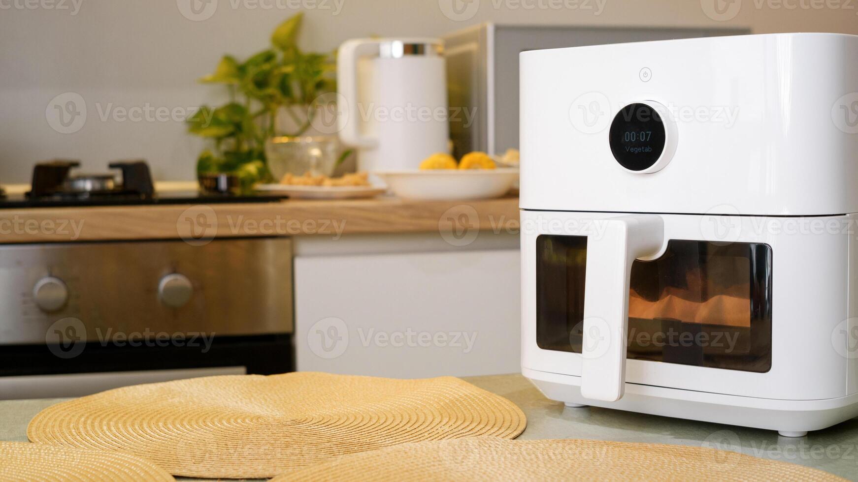 White air fryer cooking food in modern kitchen photo