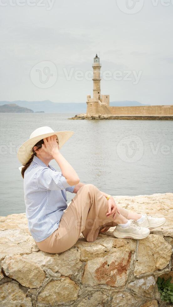 Tourist enjoying view of chania lighthouse in crete, greece photo