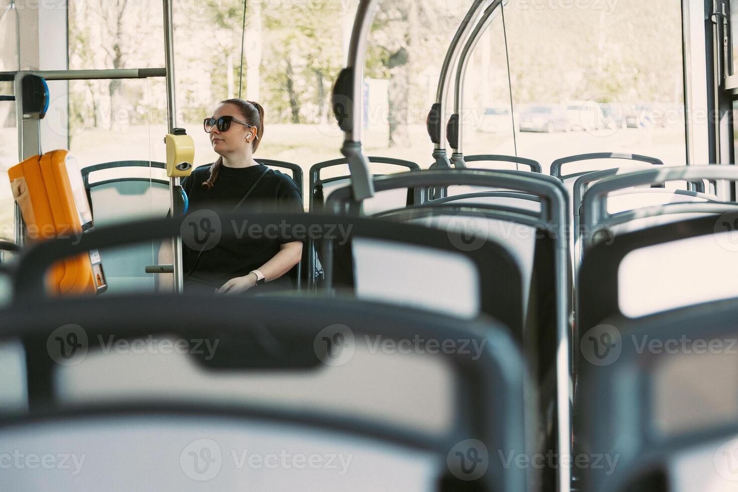 Woman commuting alone on modern city bus photo