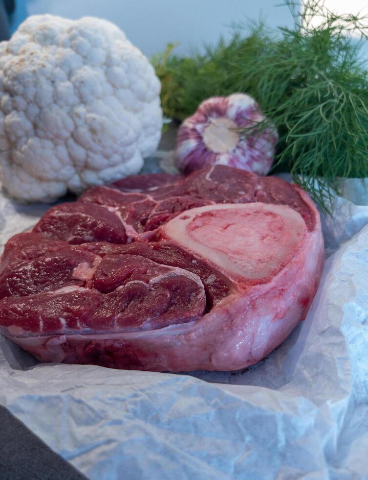 Raw Beef Shank with Bone and Fresh Vegetables on Parchment photo