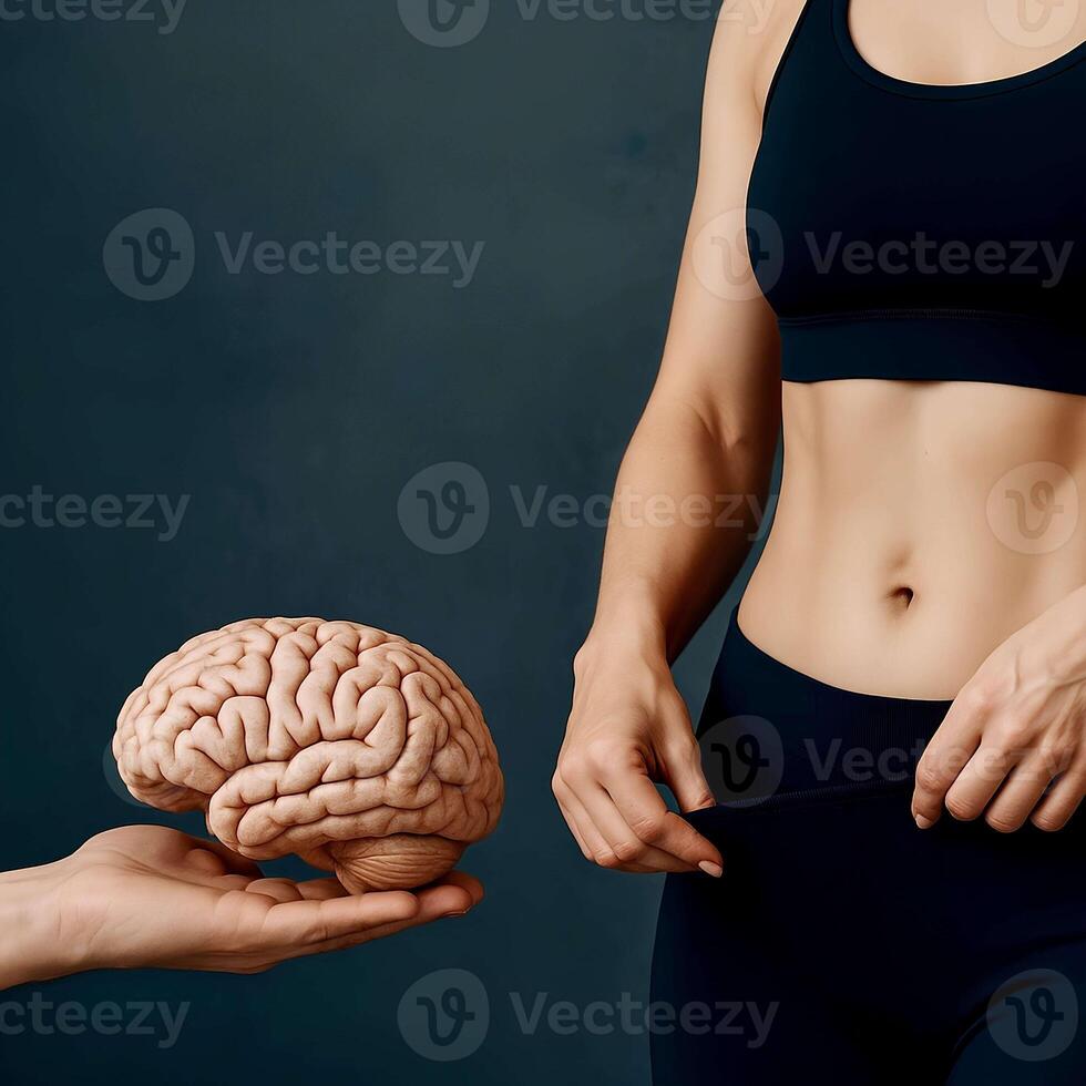 Symbolic image showing a fit woman in sportswear and a human brain held in a hand, illustrating the connection between mental focus and body transformation. Ideal for weight loss, neuroscience photo