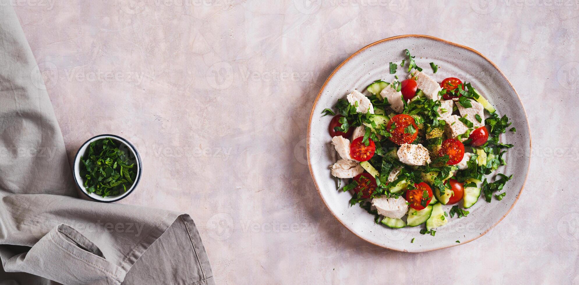 Fresh diet salad with chicken breast and vegetables on a plate on the table top view web banner photo