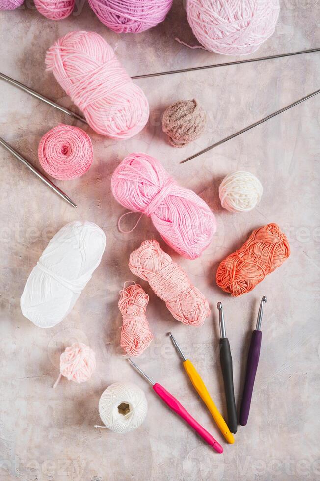 Yarn and tools for a cozy home knitting hobby on the table top and vertical view photo