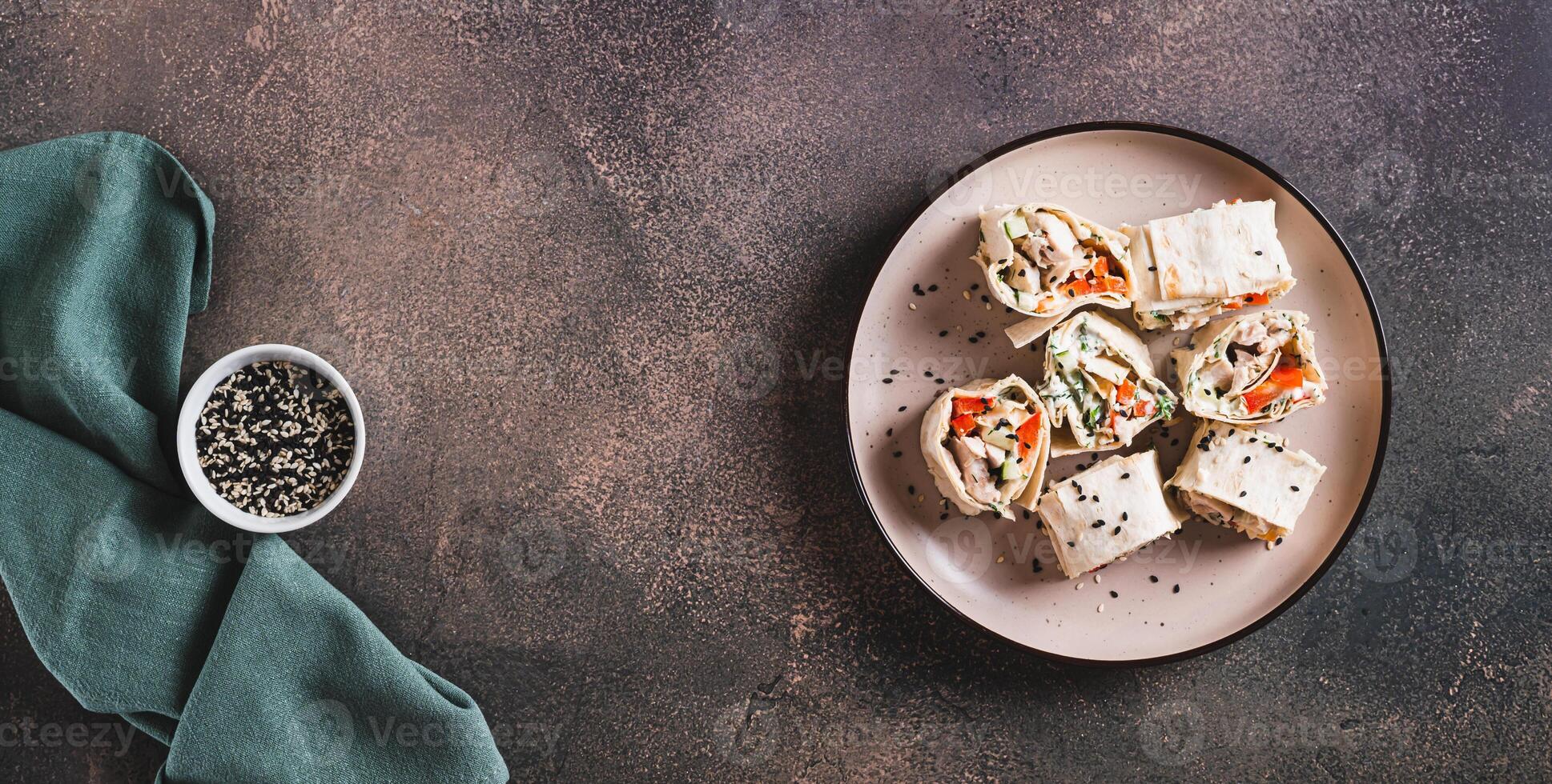 Flat bread rolls with chicken and vegetables on a plate on the table top view web banner photo