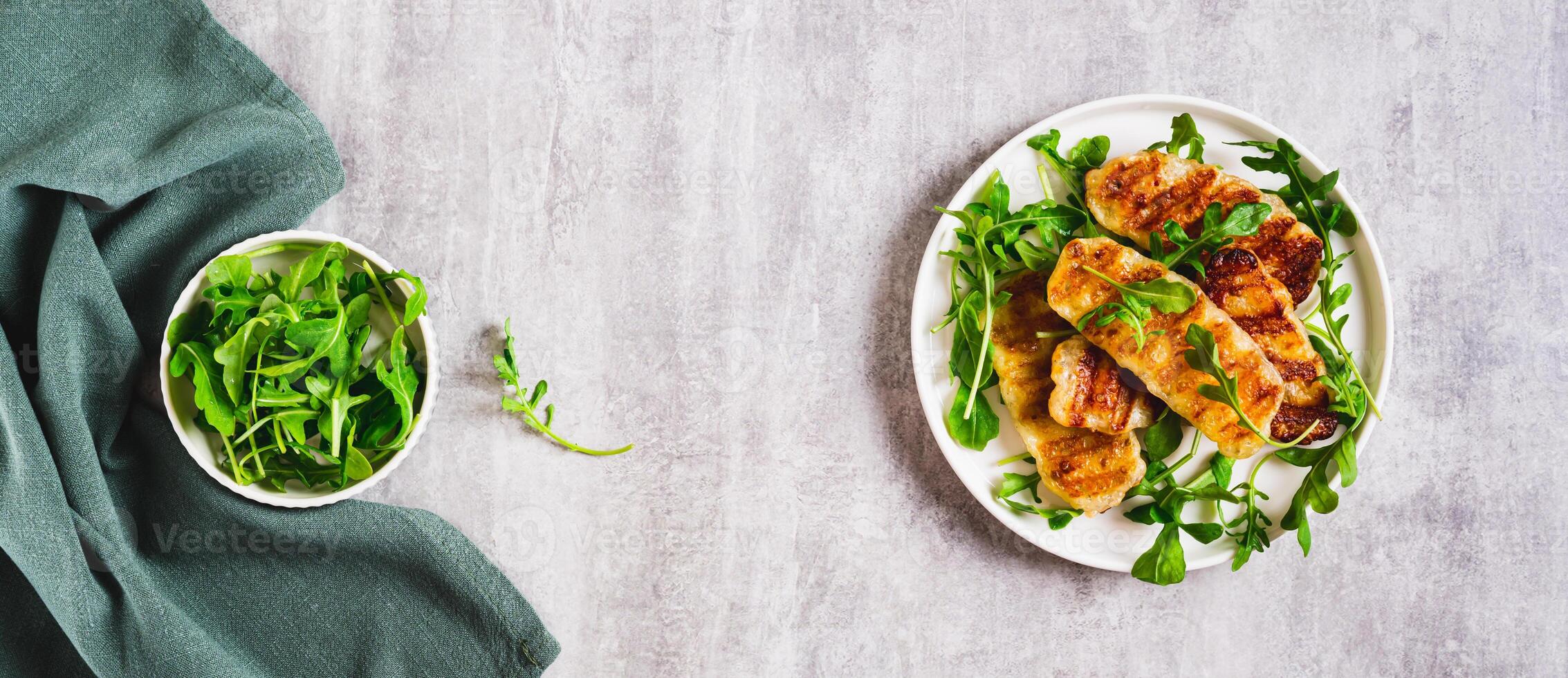 Crispy fried halloumi cheese and arugula leaves on a plate on a table top view web banner photo