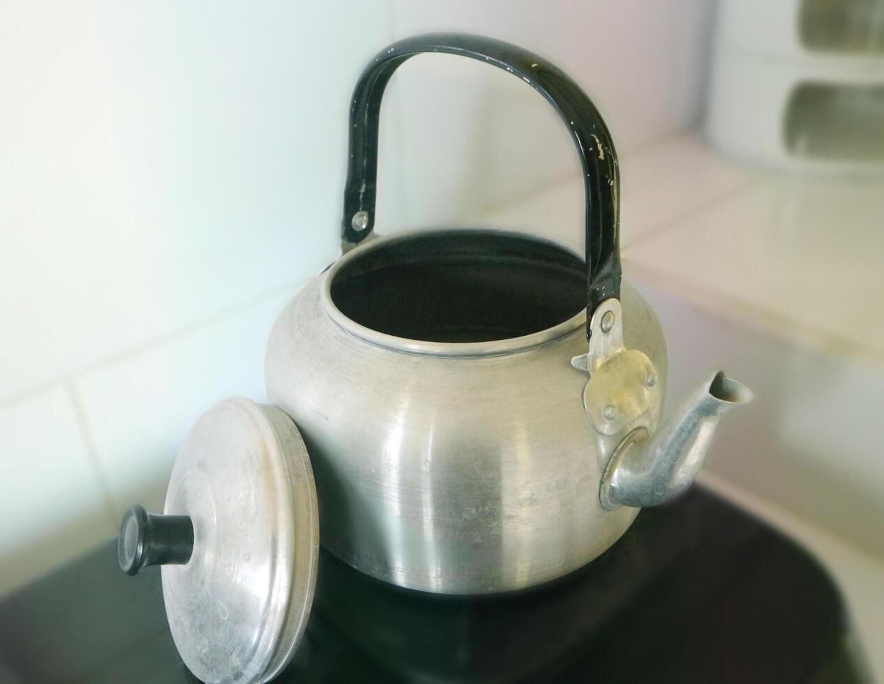 Old aluminum kettle boiling photo