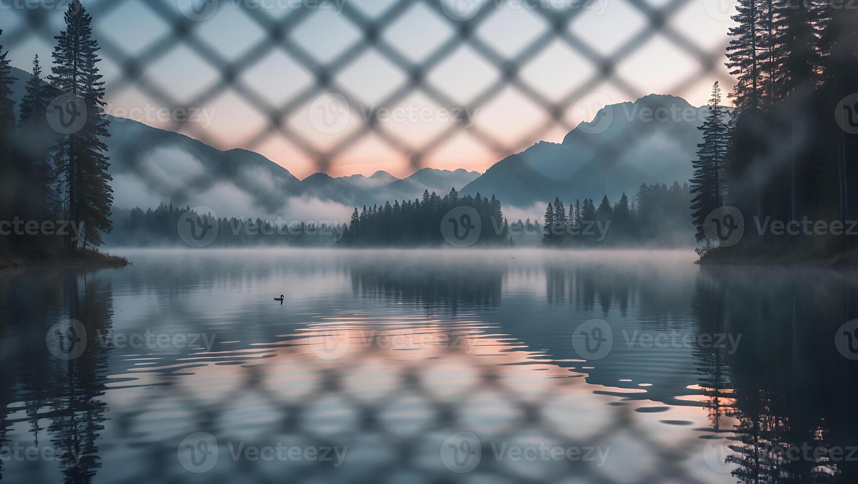 Tranquil Lake View Through Fence with Fog and Mountain Backdrop photo