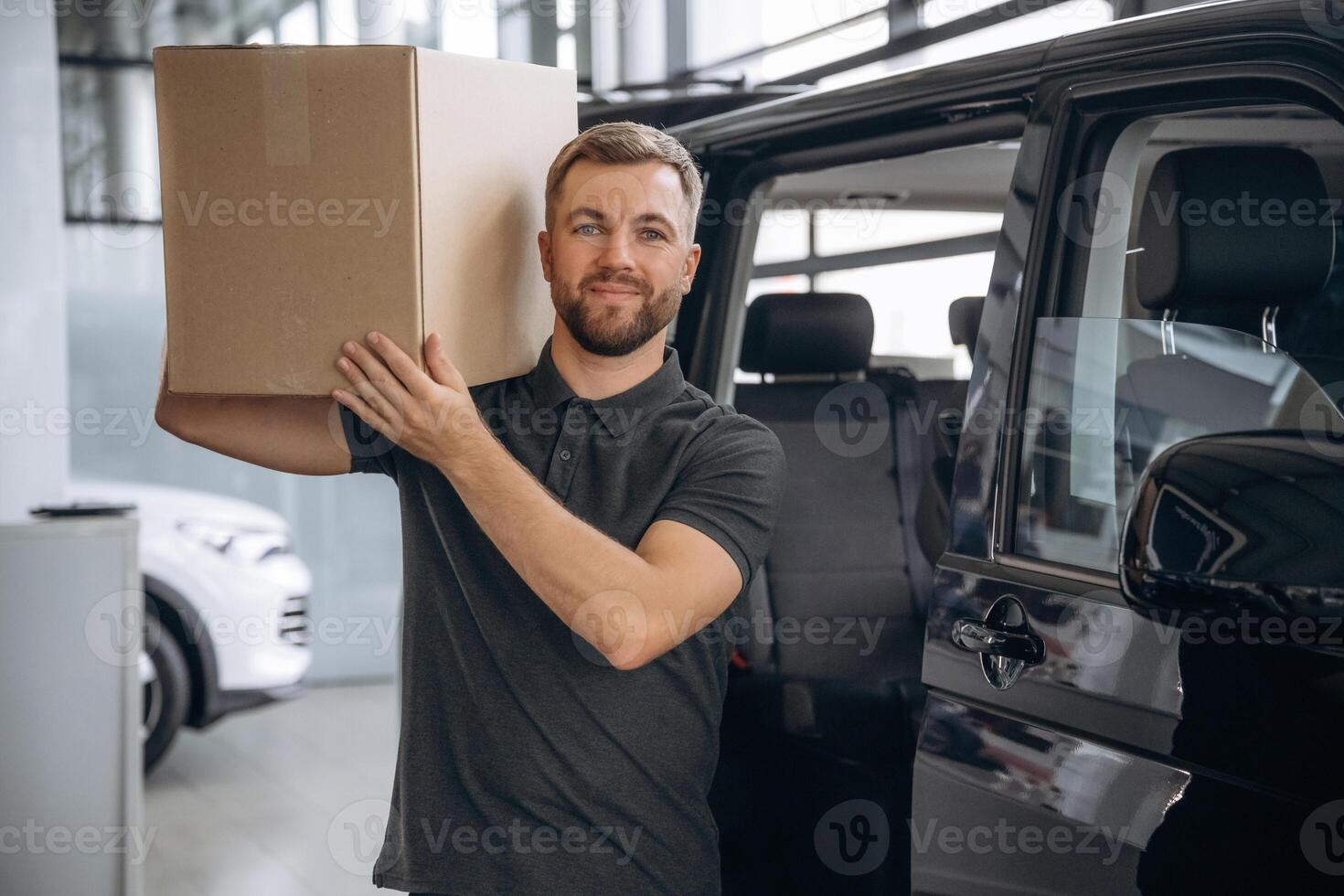 Box is on the shoulder. Delivery man or loader is near the car with. photo