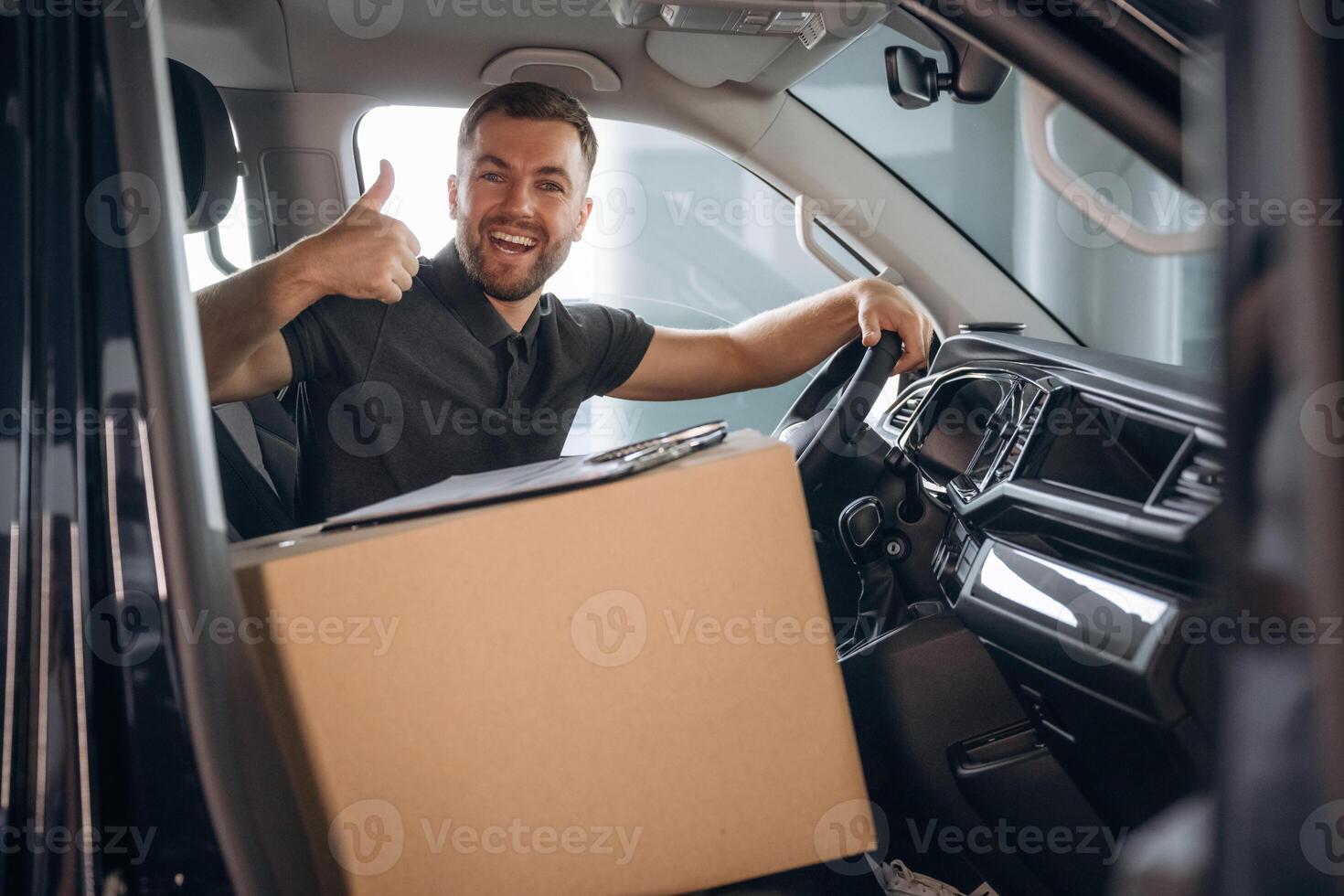 Showing, hand, gesture, everything is fine, will be done. The delivery man or a loader is in the car with box photo