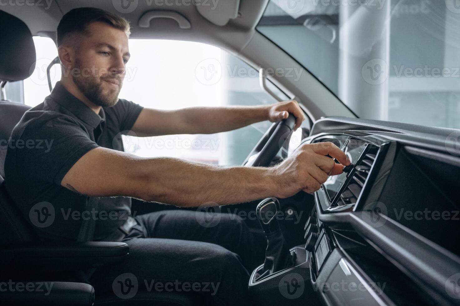 View from the side. Man is, sitting, in ,the car, driver photo