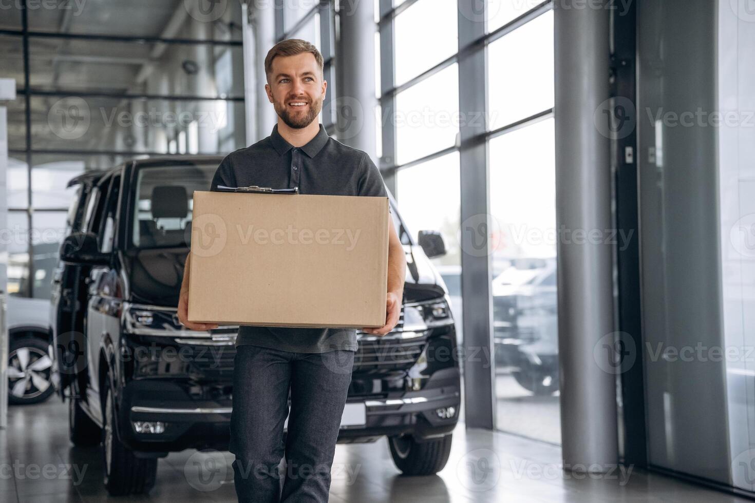 Smiling, ,positive facial ,expression.... Delivery man or loader is near the car with a box photo