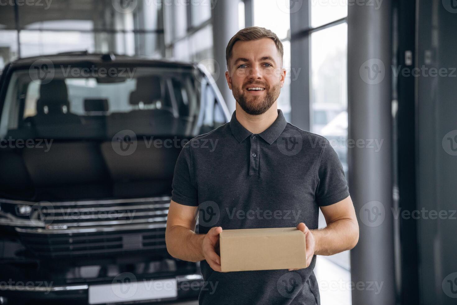 Here's your delivery... Man loader is near the car with a box photo