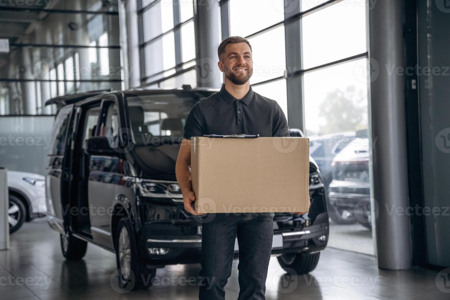 Fast delivery ,service,,, standing. Man loader is near the car with a box photo