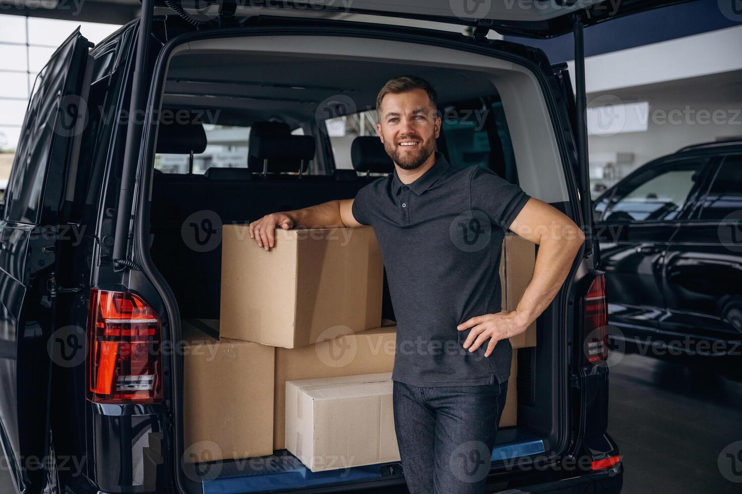 Unloading the,, boxes. Delivery man or loader is near the car photo