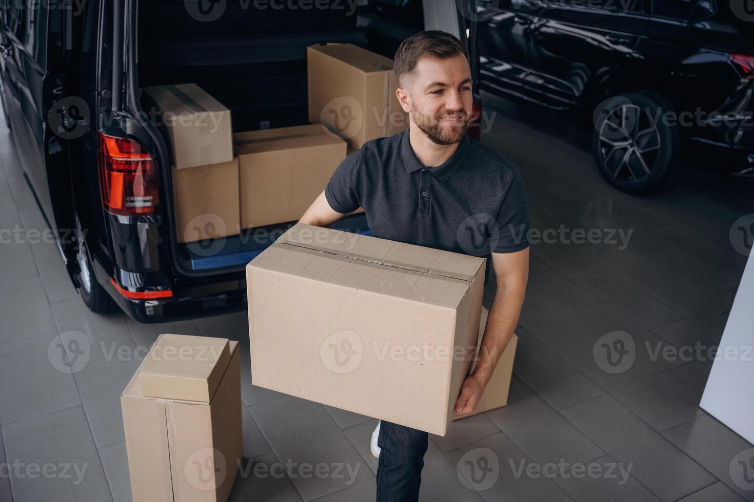 Unloading, the boxes. Delivery man or loader is near the car photo
