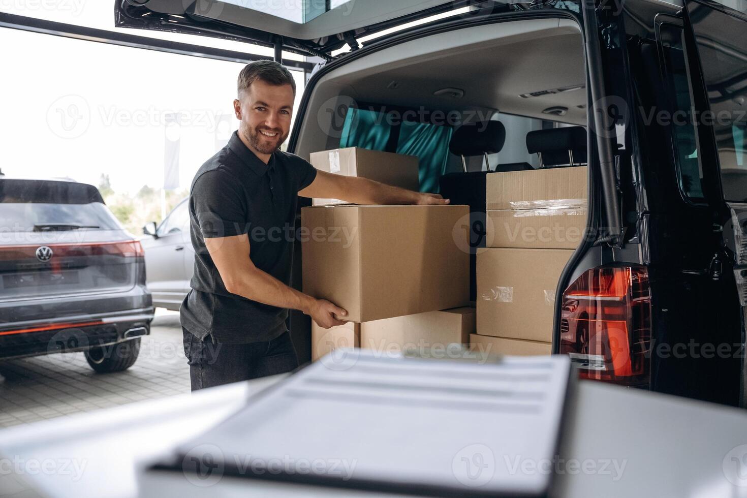 Delivery, man or loader is near the car with a box photo