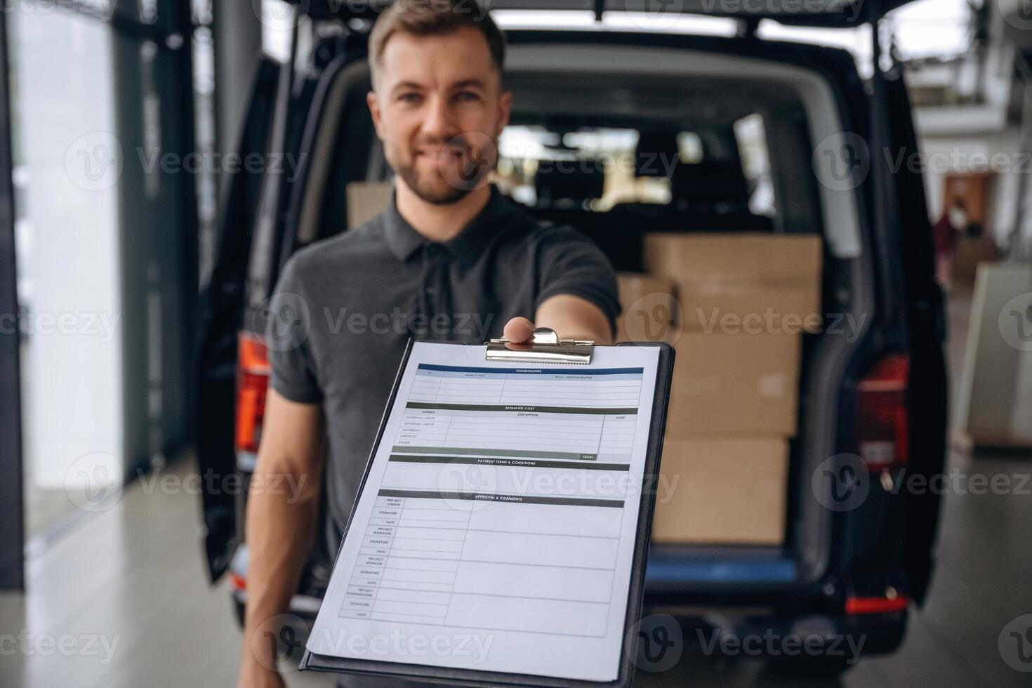 Confirm the, order on notepad. Delivery man or loader is near the car with a box photo