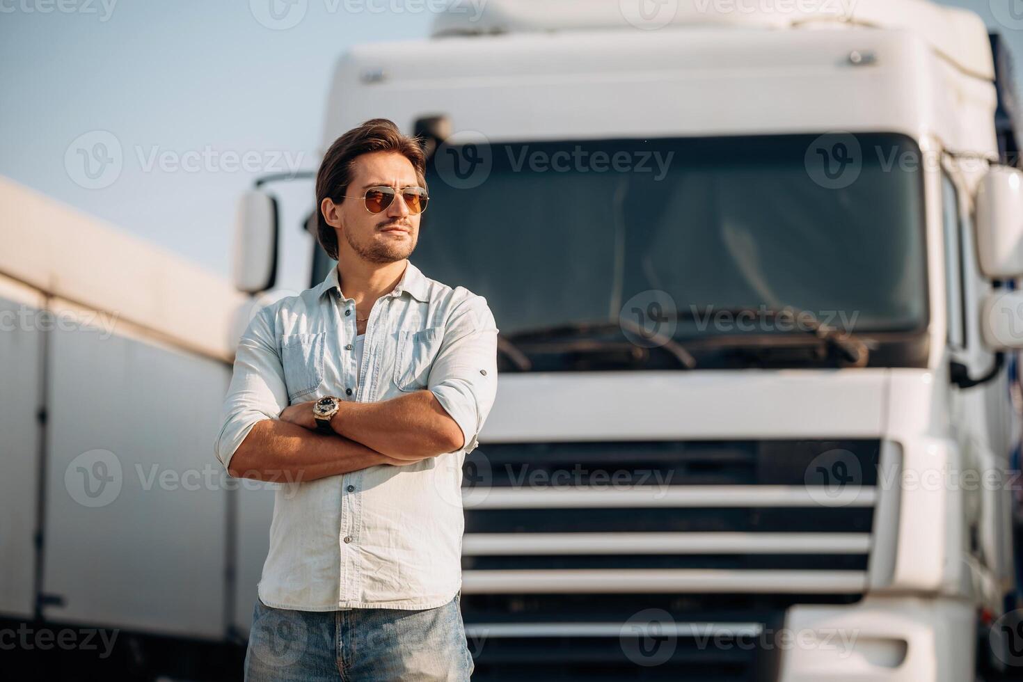 Eyewear, cool look ,in ,,the sunglasses, standing. Truck driver is near the transport outdoors photo