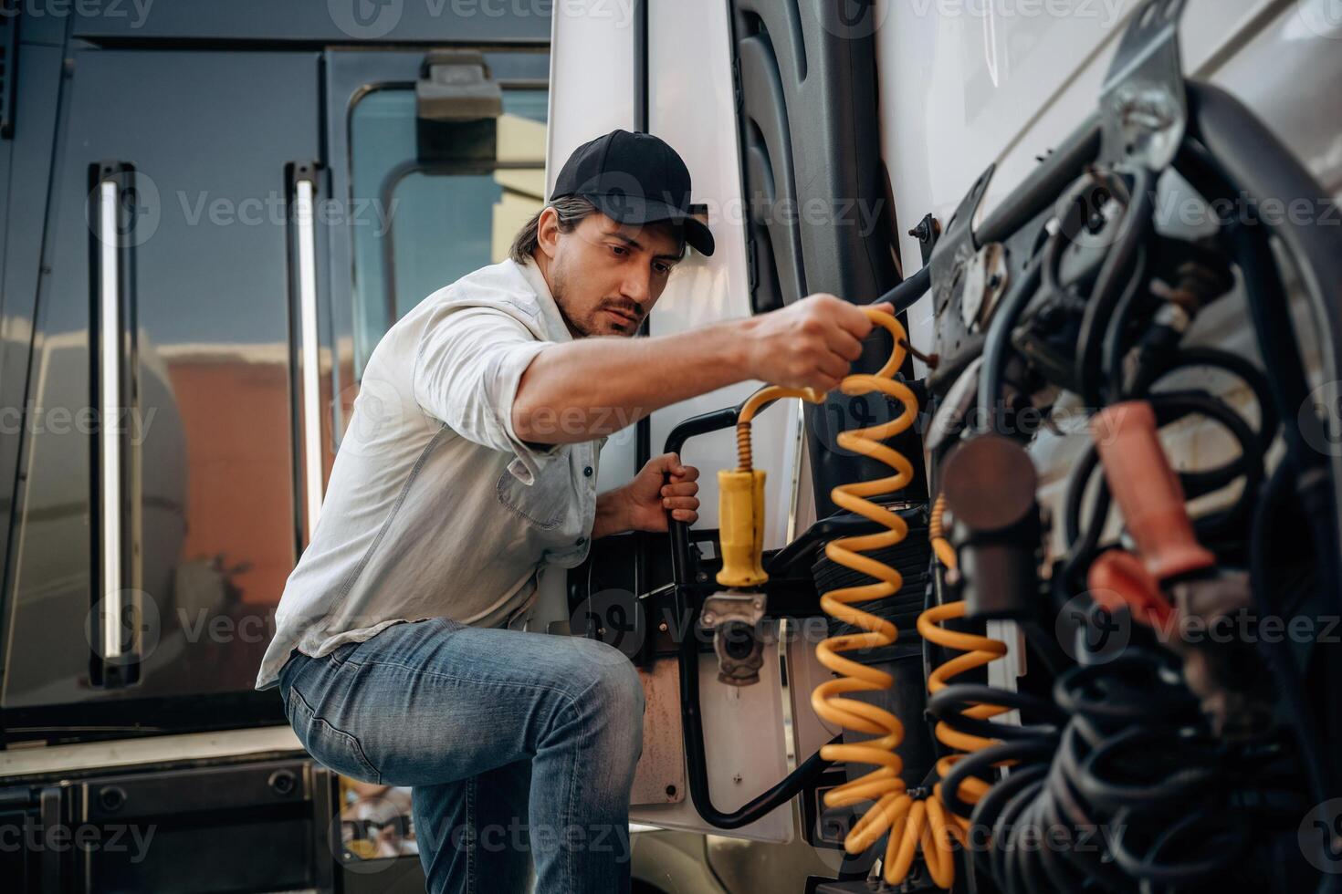 Messing with ,cables, installation, fix. Truck driver is near the transport outdoors photo