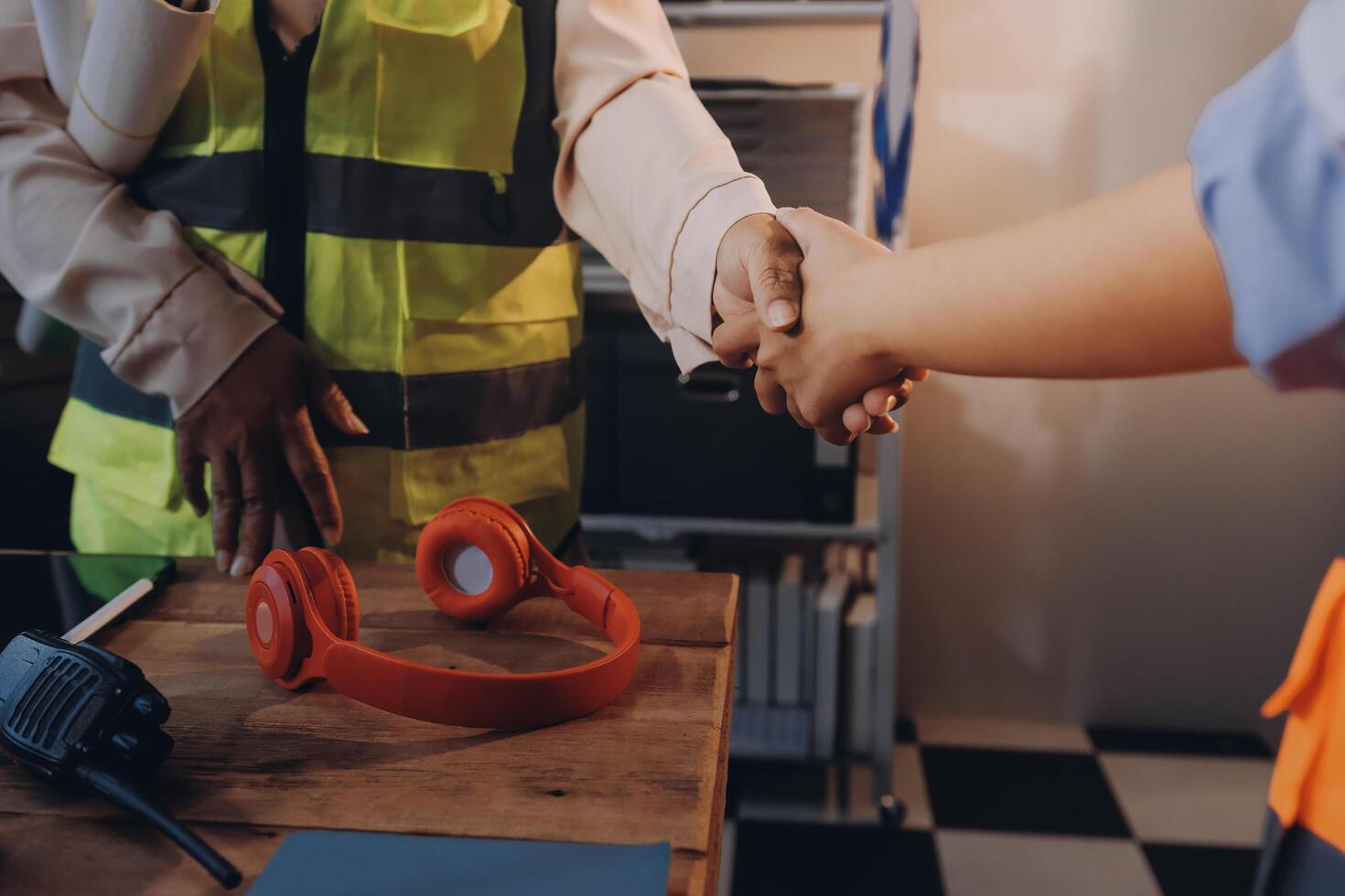 Two people shaking hands at a desk with headphones photo