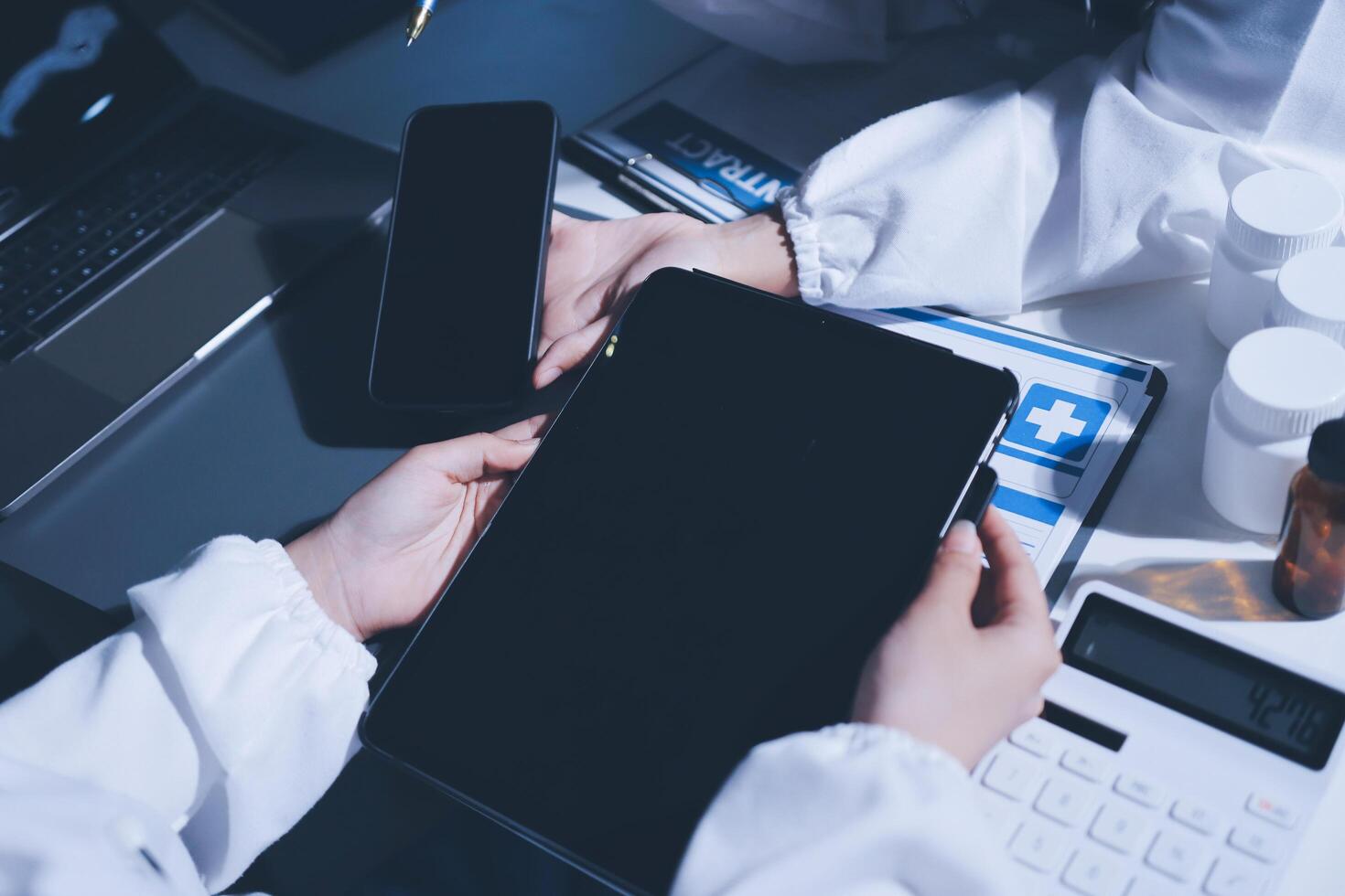 A doctor holding a tablet computer and a laptop photo