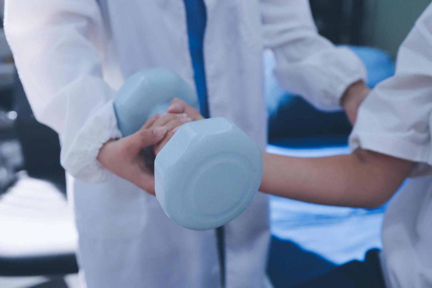 A doctor holding a blue dumbbell in his hand photo