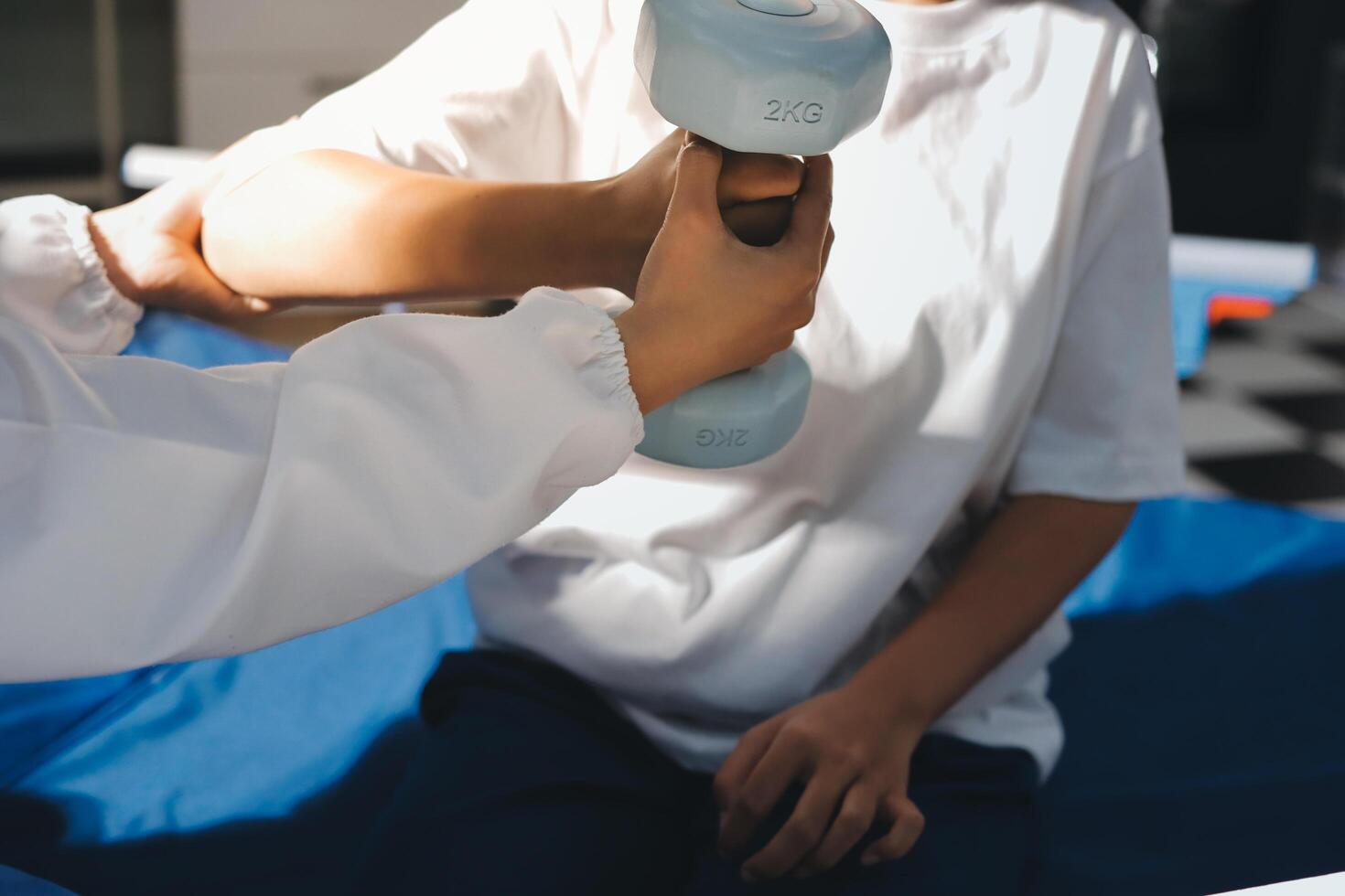 A woman is holding a dumbbell while sitting on a bed photo