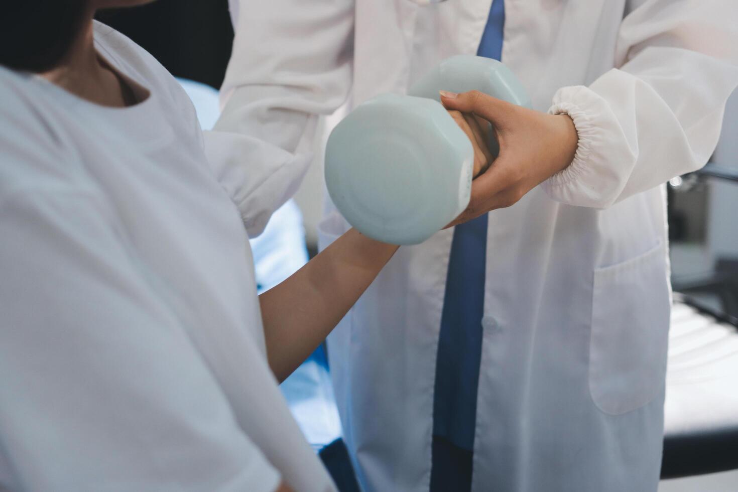 A doctor is holding a blue object to a woman's hand photo