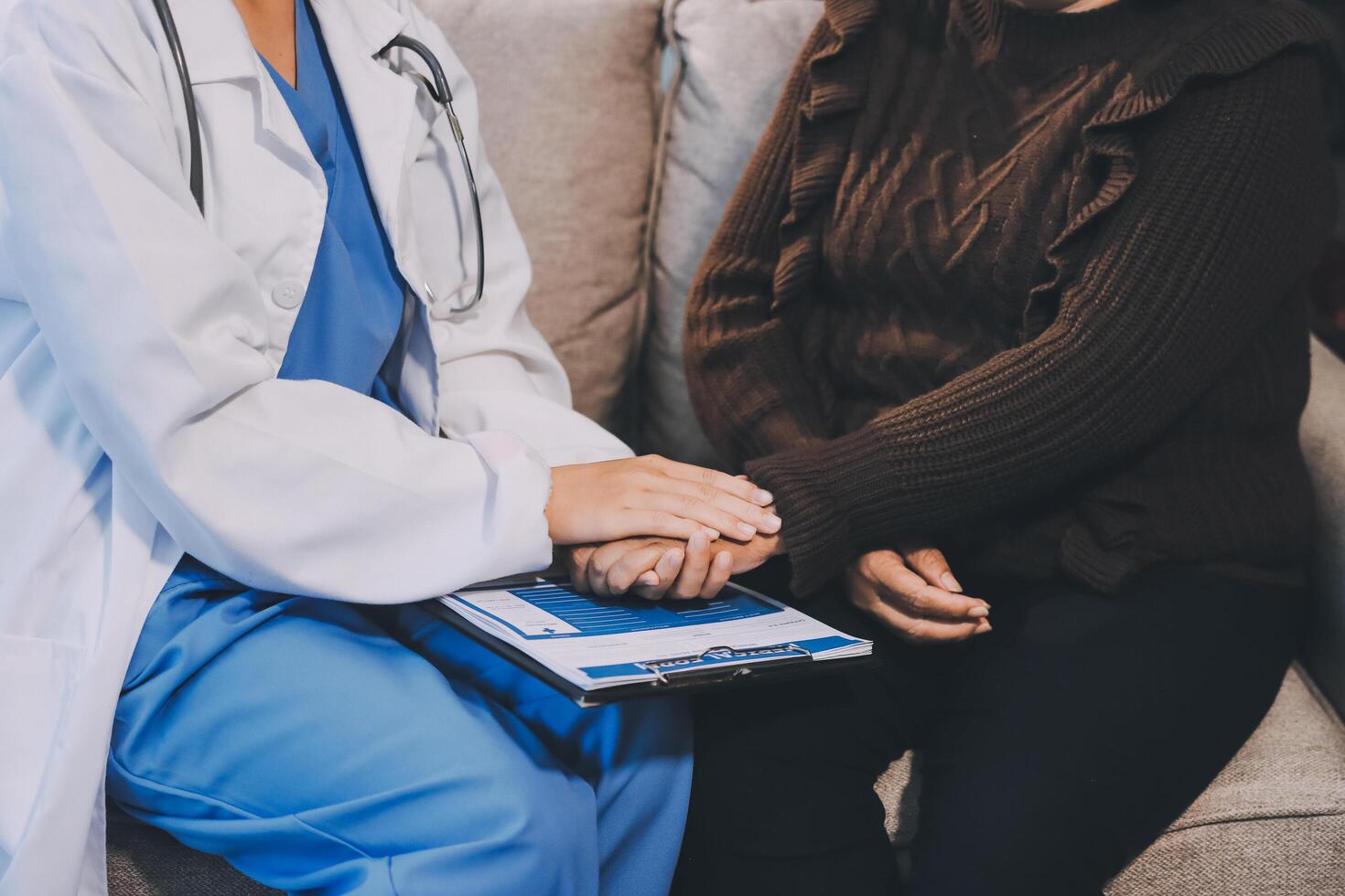 A doctor is holding the hand of an older woman photo