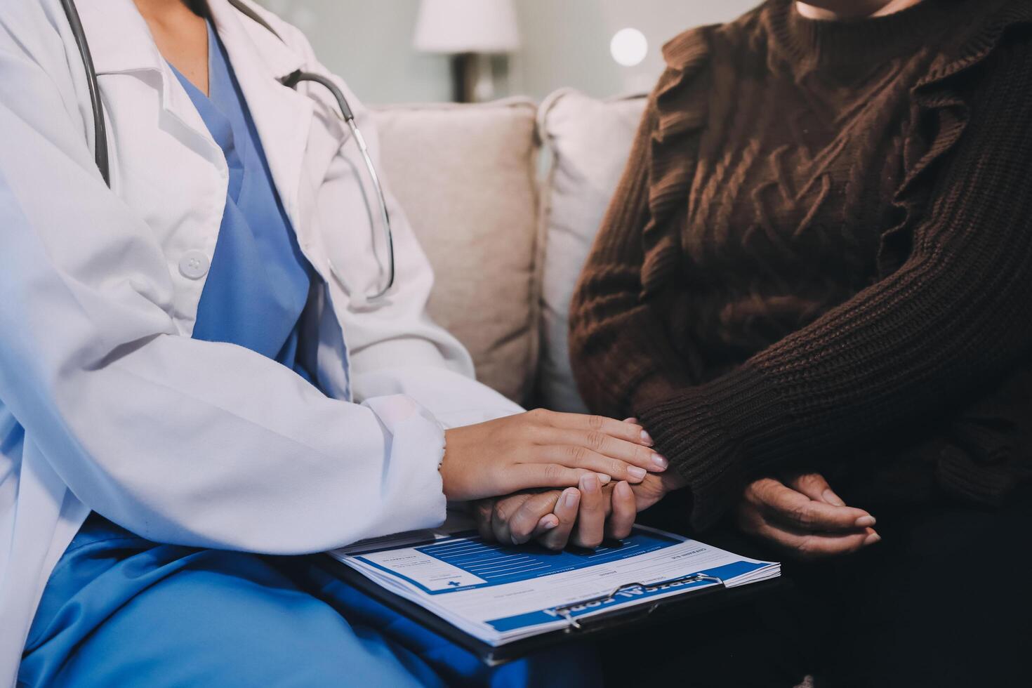 A doctor holding hands with an older woman photo