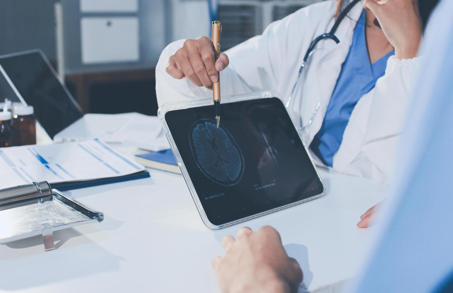 A doctor is looking at a tablet computer screen photo