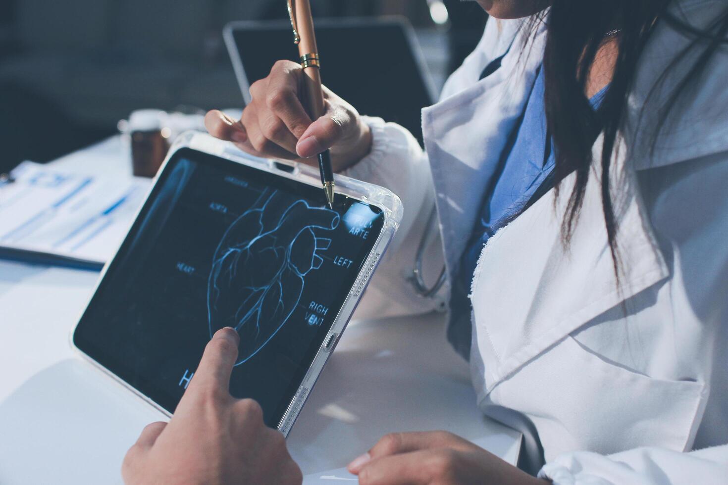 A doctor is using a tablet to show a patient a heart photo