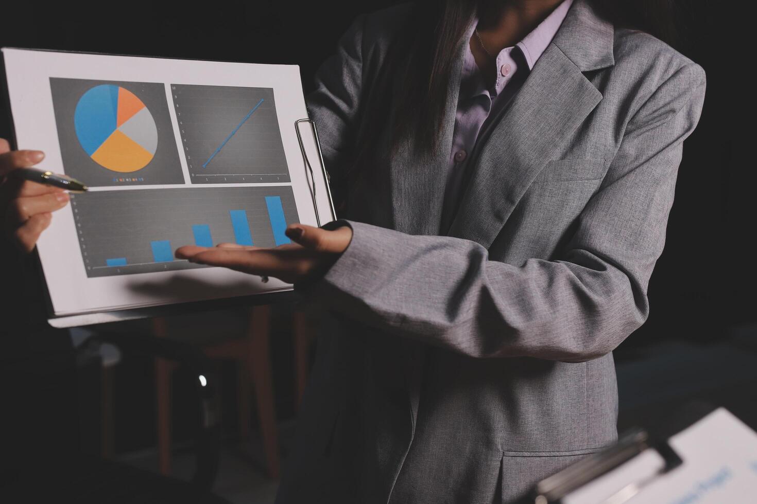 A woman in a business suit holding a tablet with graphs and charts photo